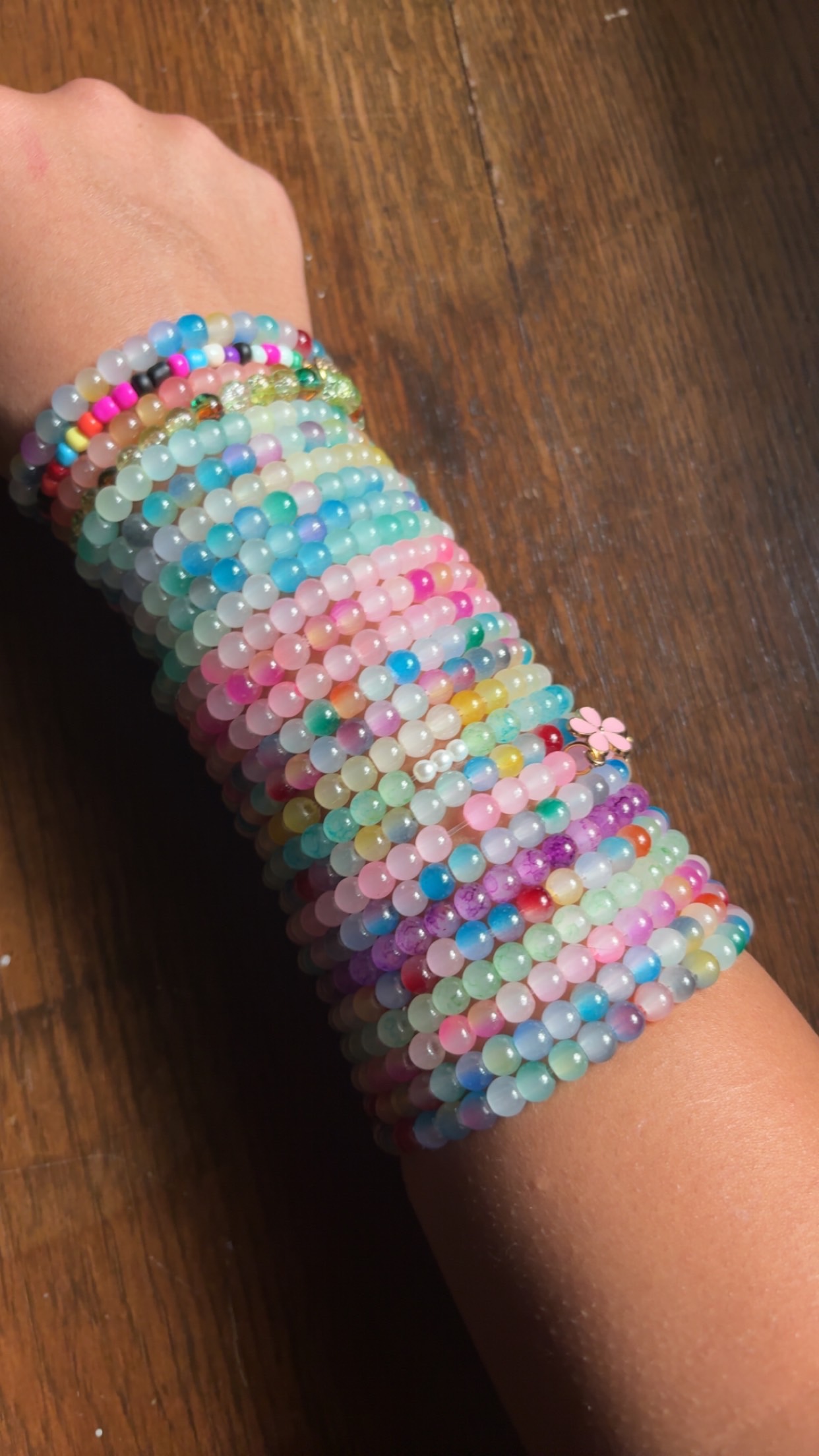 An arm stacked with colorful handmade Perfect Pair beaded bracelets